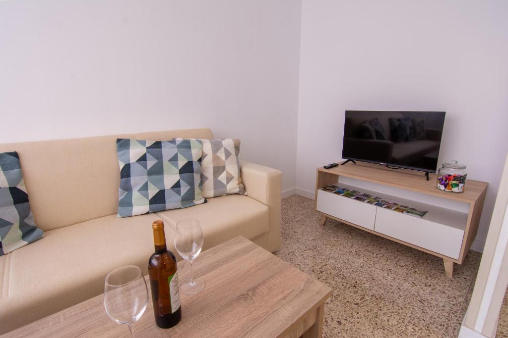 een woonkamer met een bank en een fles wijn bij Tendal Hosting - Cabrera Guerra in Santa Cruz de la Palma