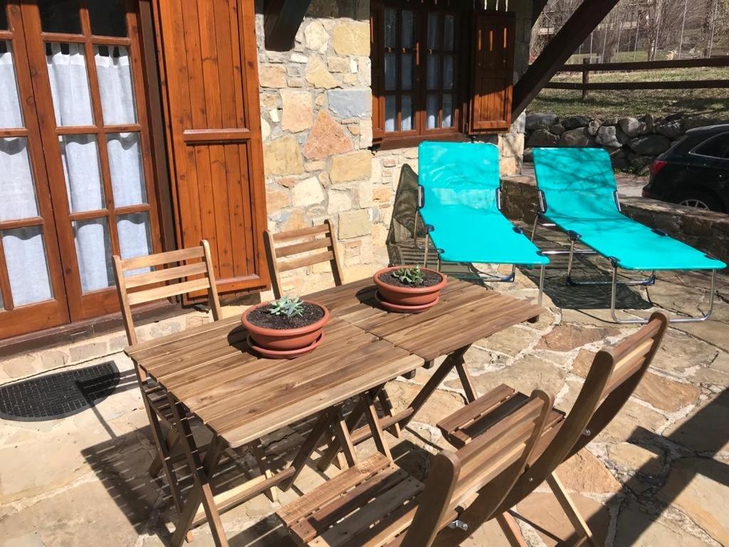 una mesa de madera y sillas en un patio en la Caseta Boi Taull - 2 habitaciones, en Pla de l'Ermita