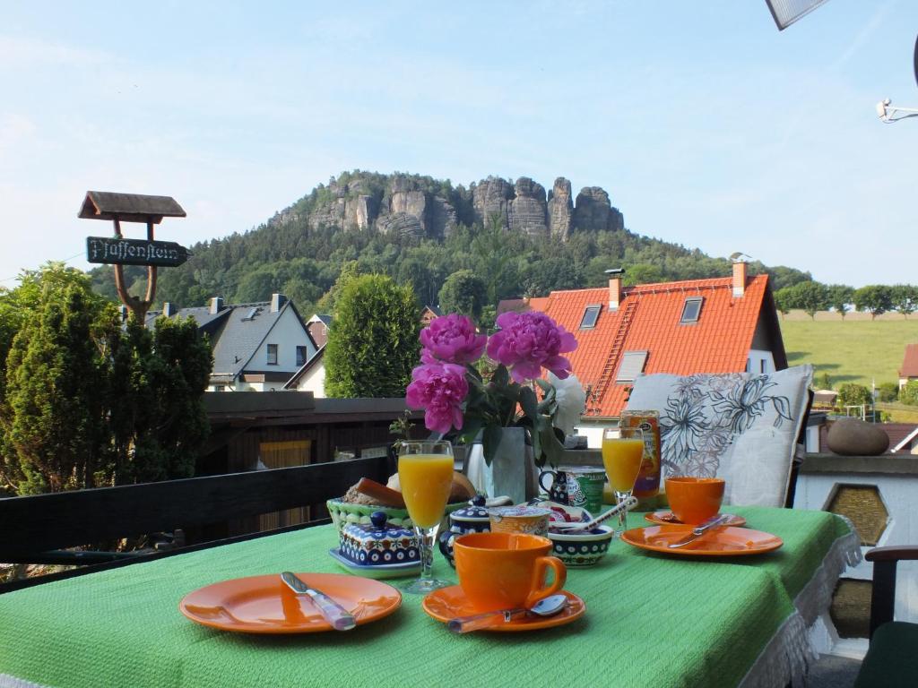 un tavolo verde con cibo e bevande su un balcone di Pfaffensteinblick Reymann a Königstein