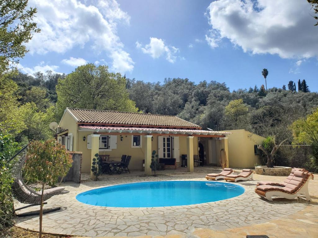 uma villa com piscina em frente a uma casa em Villa Stefania em Ágios Ioánnis