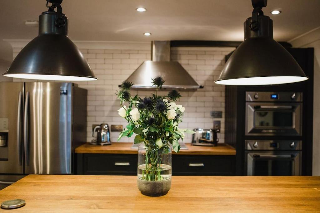 eine Vase mit Blumen auf dem Tisch in der Küche in der Unterkunft •MangoHausLondon• •airconditioned•garden•fire pit• in London