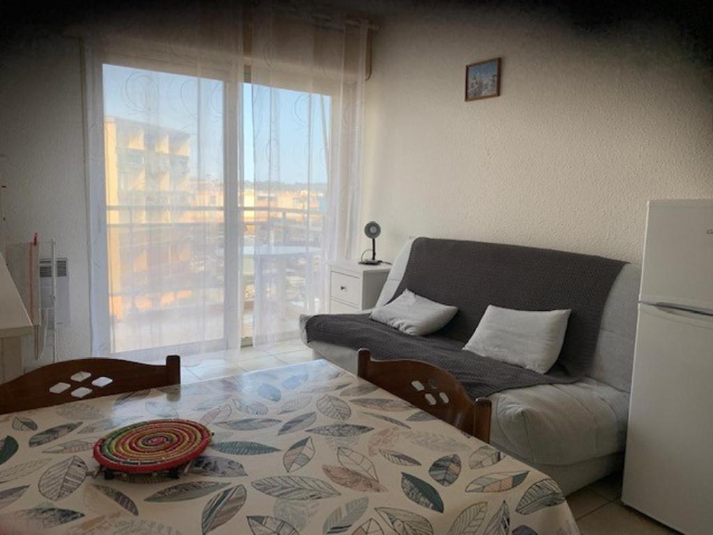 un salon avec un canapé et une grande fenêtre dans l'établissement Studio cosy à Balaruc-les-Bains - Animaux admis, proche Thermes - FR-1-503-98, à Balaruc-les-Bains