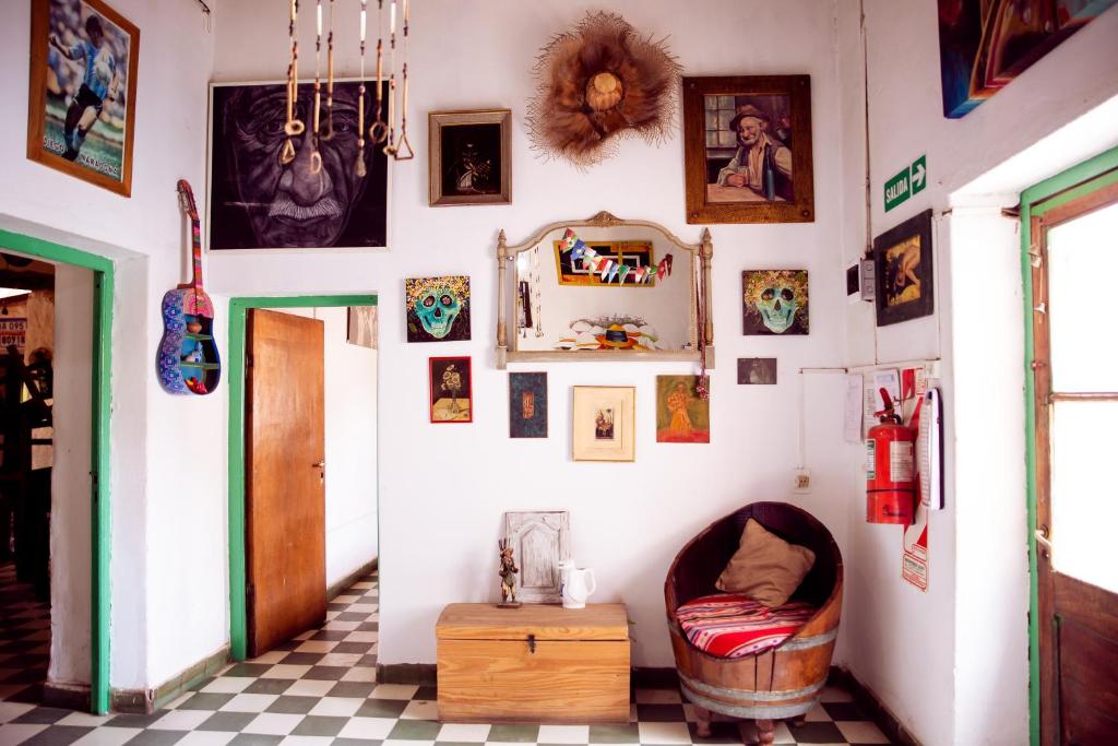 Habitación con una pared llena de cuadros y una mesa. en Apapacho Hostel en Tilcara