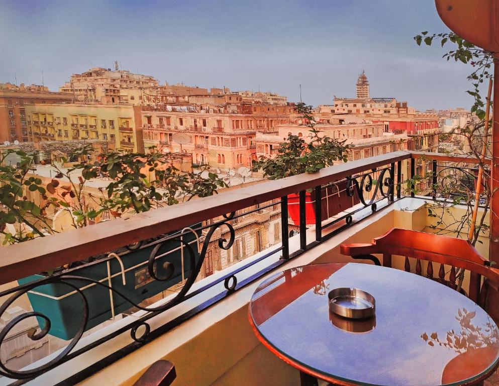 a table on a balcony with a view of the city at Cairo House Hostel in Cairo