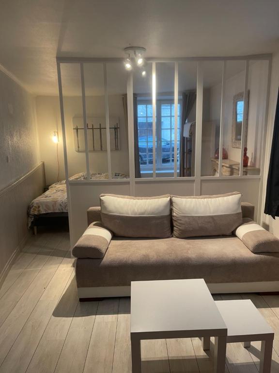 een woonkamer met een bank en een bed bij Nid Carmin in Suèvres