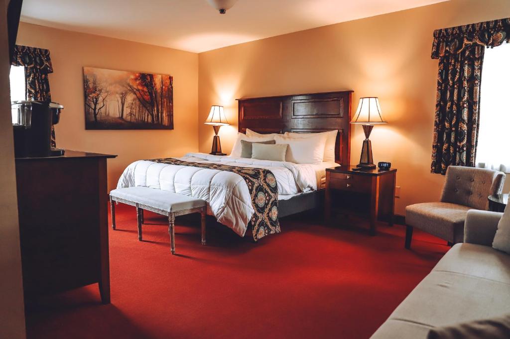 um quarto de hotel com uma cama e uma cadeira em Tom Quick Inn em Milford