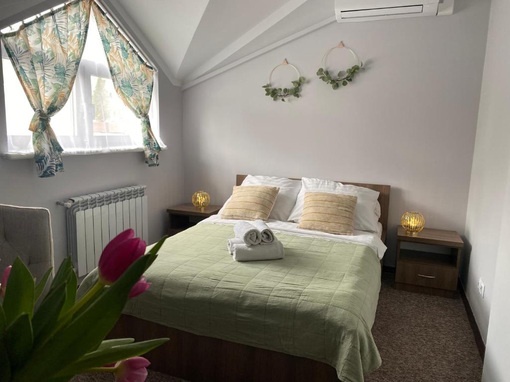 ein Schlafzimmer mit einem Bett mit einer grünen Decke in der Unterkunft Pokoje Bakos Radocza in Radocza