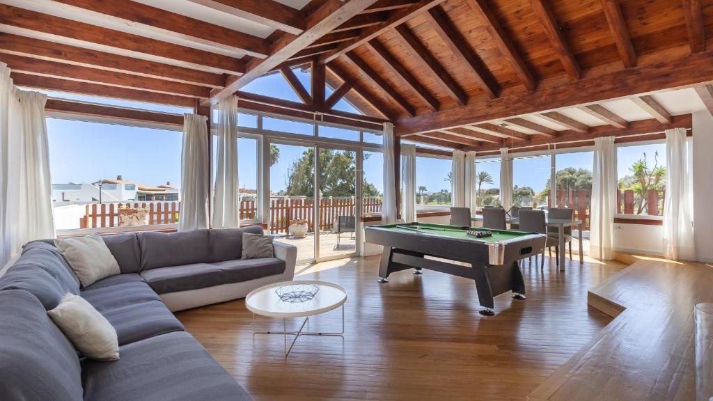 a living room with a couch and a pool table at Luxury Villa Nieve in Caleta De Fuste