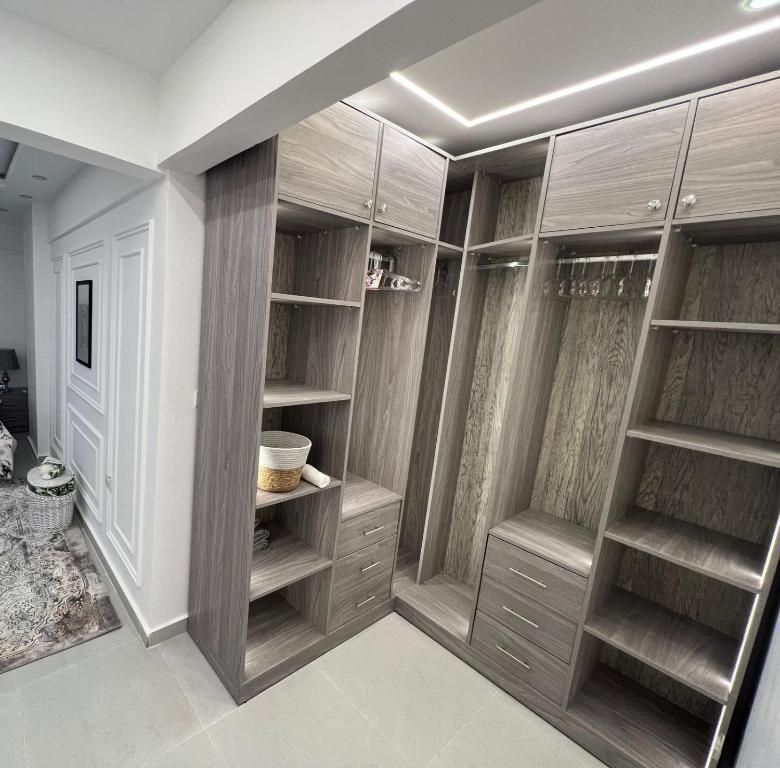 a walk in closet with wooden cabinets and shelves at Pyramids View Apartment in Giza