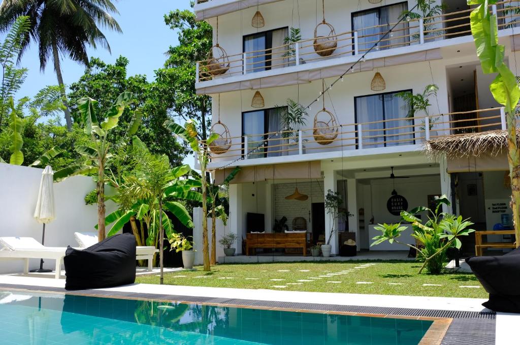 a hotel with a swimming pool in front of a building at OASIA - Boutique Surf House (ADULTS ONLY) in Weligama