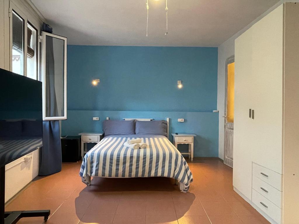 1 dormitorio azul con 1 cama con paredes azules en P&R hostals Can Tort, en Tossa de Mar