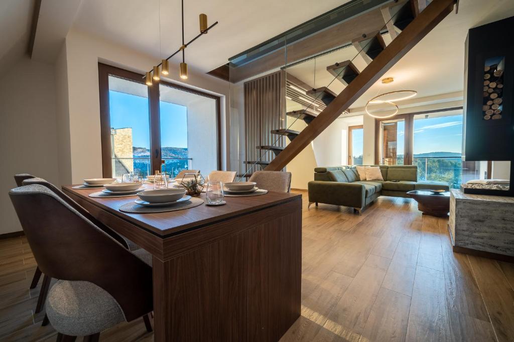 a dining room and living room with a table and chairs at BOROVI ROYAL wellness&spa in Divčibare