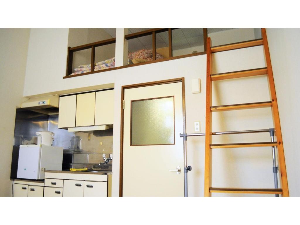 a room with a kitchen with a ladder and a door at Petit Hotel Koizumi - Vacation STAY 85672v in Lake Toya