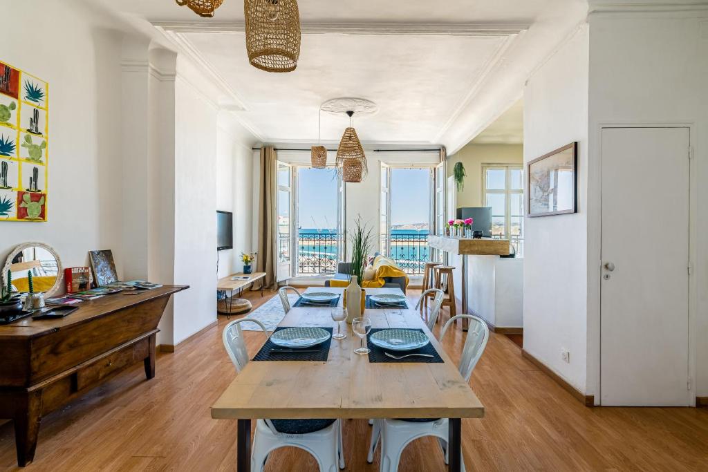 une salle à manger avec une longue table et des chaises dans l'établissement T2 vue mer au pied de La Major, à Marseille