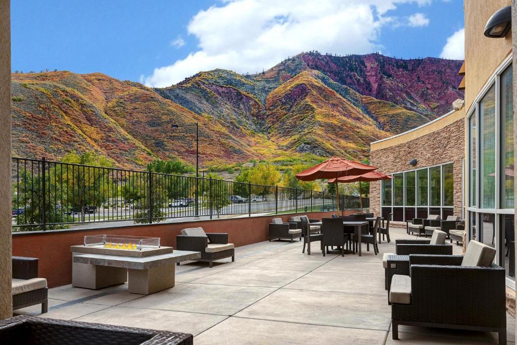 a patio with tables and chairs with mountains in the background at Courtyard by Marriott Glenwood Springs in Glenwood Springs