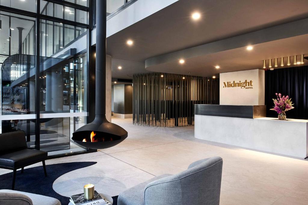 a lobby with a fireplace in a building at Midnight Hotel, Autograph Collection in Canberra