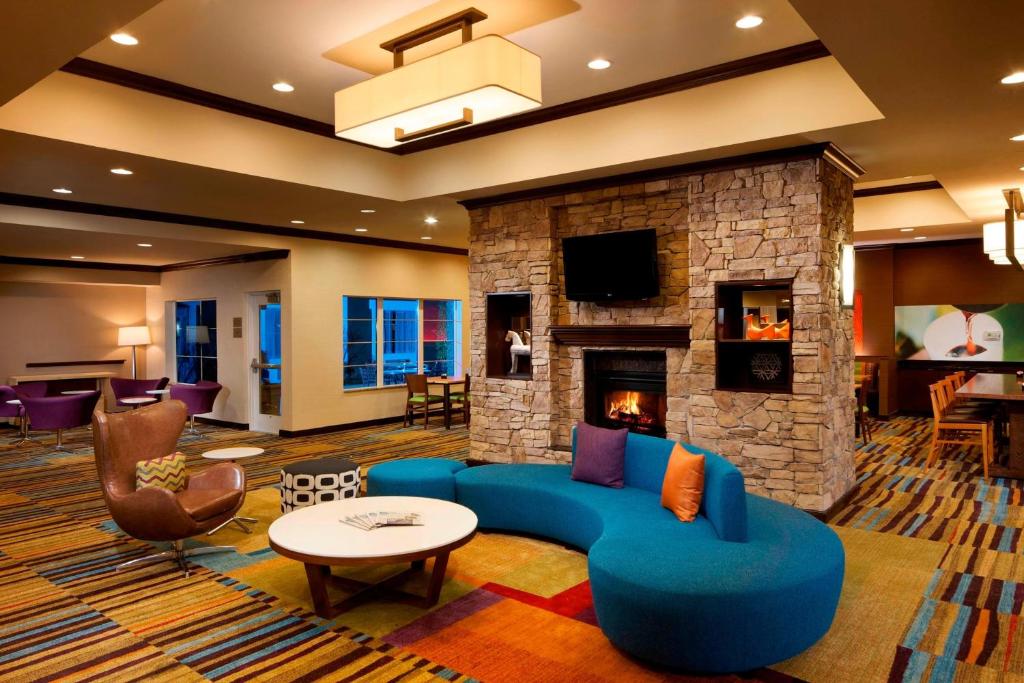 休斯頓的住宿－休斯頓洲際機場費爾菲爾德客棧，客厅设有蓝色的沙发和壁炉