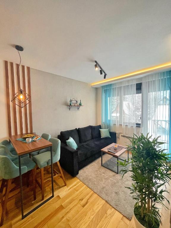 a living room with a couch and a table at Apartman Bella, Titova Vila, Zlatibor in Zlatibor
