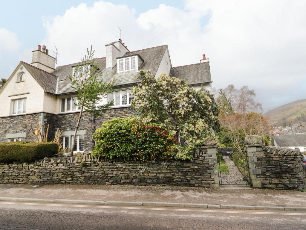 a house on the side of a stone wall at Connie's Cottage in Ambleside