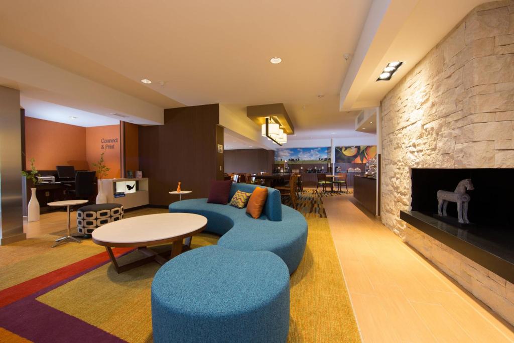a living room with a blue couch and a fireplace at Fairfield Inn & Suites Burlington in Burlington