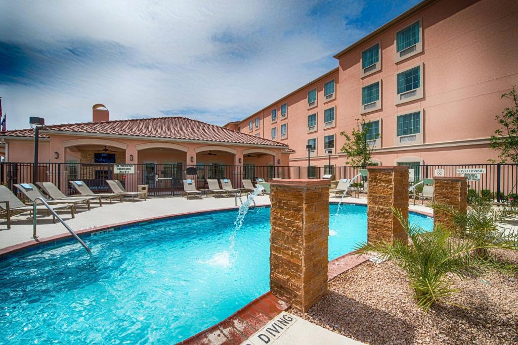 a swimming pool with a fountain in front of a building at TownePlace Suites by Marriott El Paso Airport in El Paso