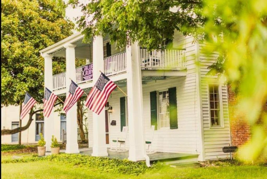 a white house with american flags on it at Blue Ruby at Grice-Fearing B&B in Elizabeth City