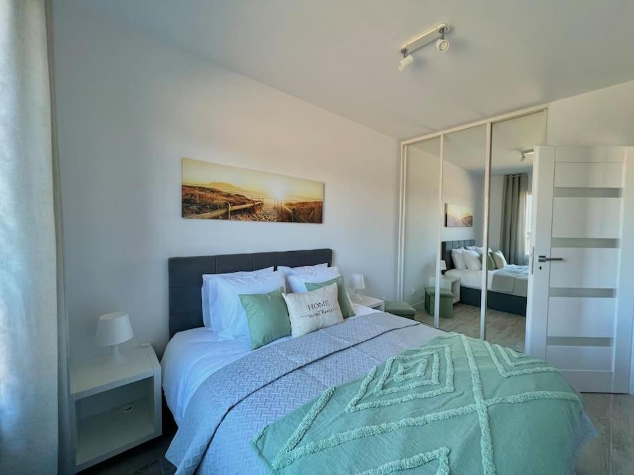 a bedroom with a large bed and a mirror at Apartment Olive in Białołęka-Tarchomin Center in Warsaw