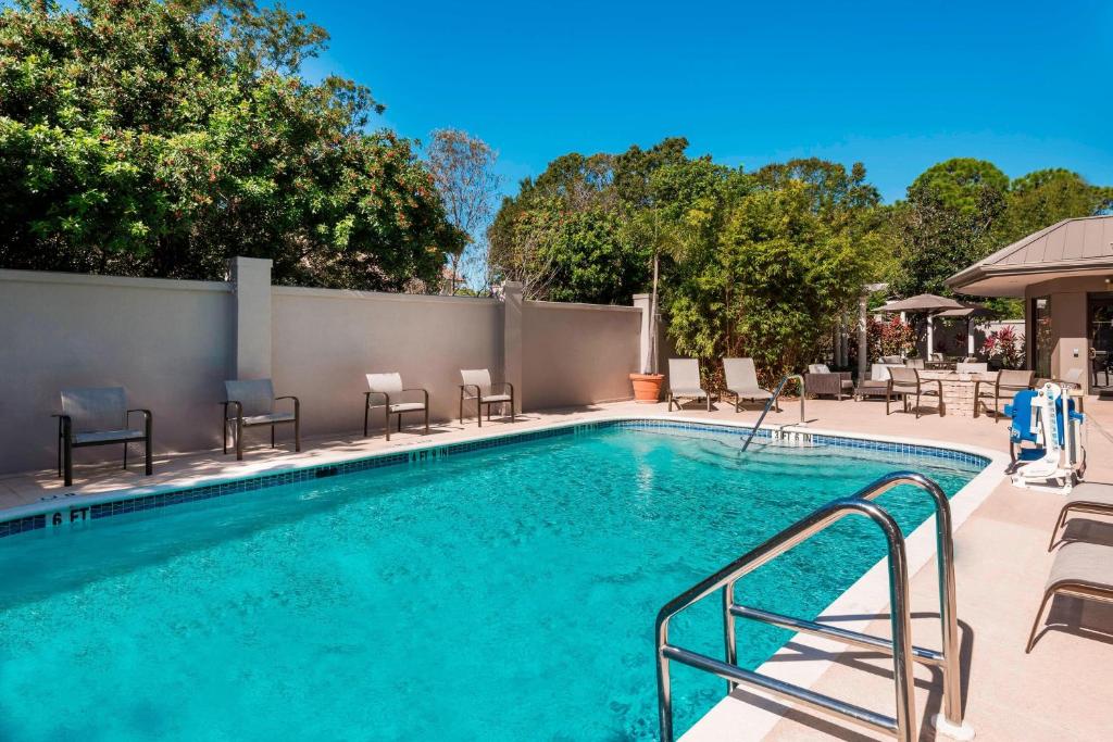 una gran piscina con sillas y una valla en Courtyard Sarasota Bradenton Airport, en Sarasota