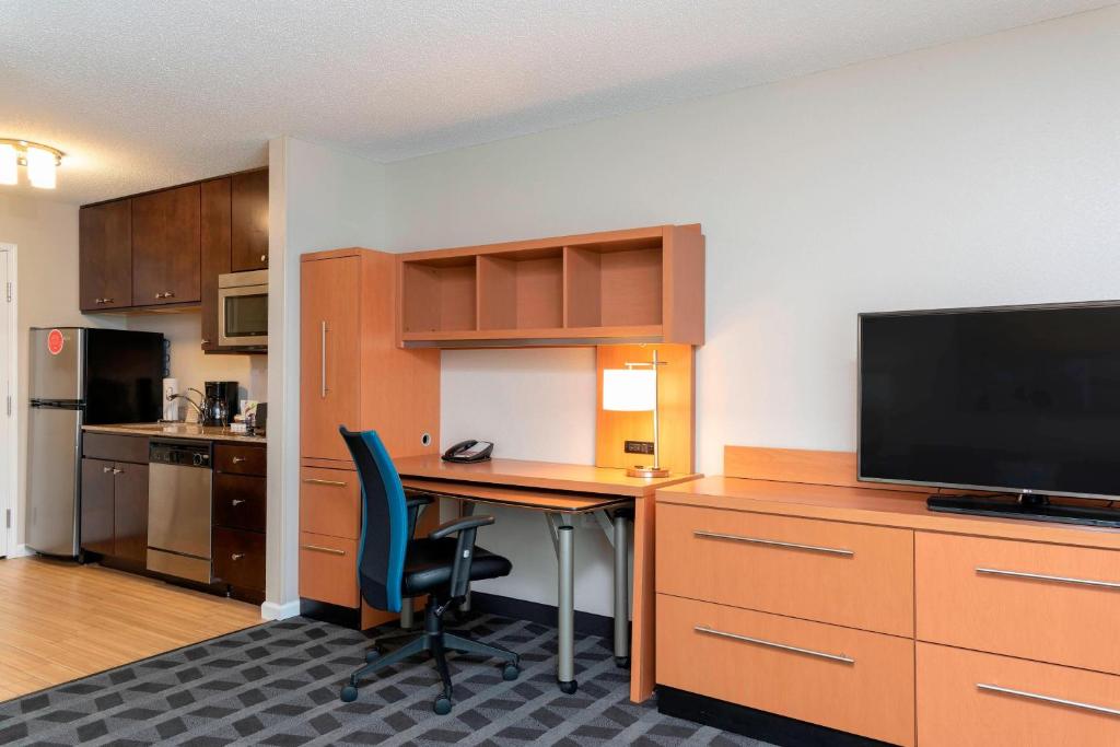 an office with a desk with a computer and a tv at TownePlace Suites Fort Wayne North in Fort Wayne