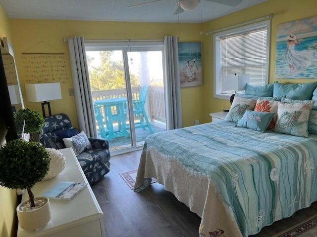 a bedroom with a large bed and a balcony at SunSet Terrace, Avon NC in Avon