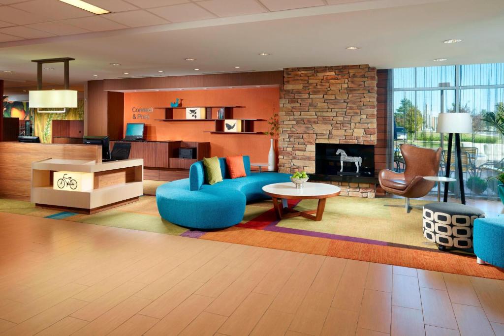 sala de estar con sofá azul y chimenea en Fairfield Inn & Suites by Marriott Fayetteville North en Fayetteville