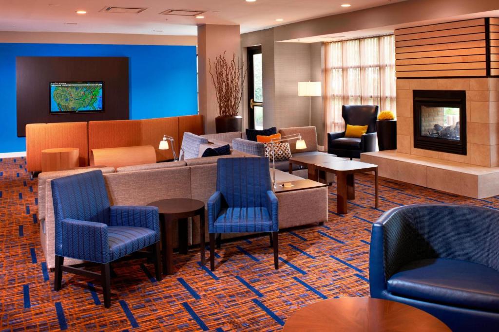 een lobby met een wachtkamer met blauwe stoelen bij Courtyard Cincinnati Covington in Covington