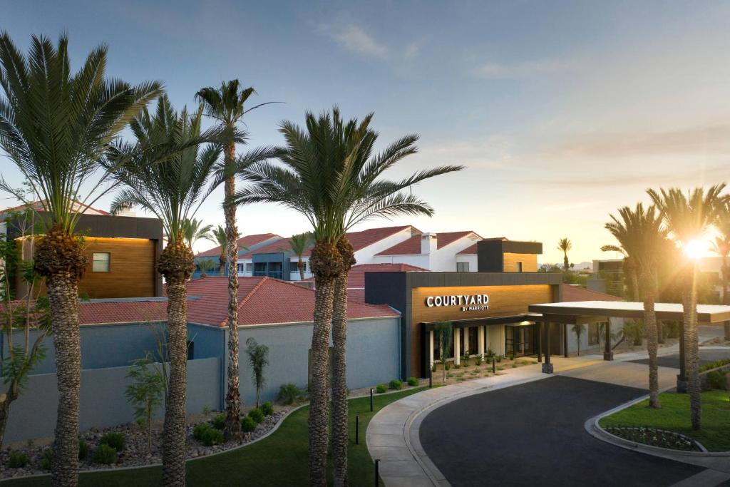 a resort with palm trees in front of a building at Courtyard by Marriott Phoenix Mesa in Mesa