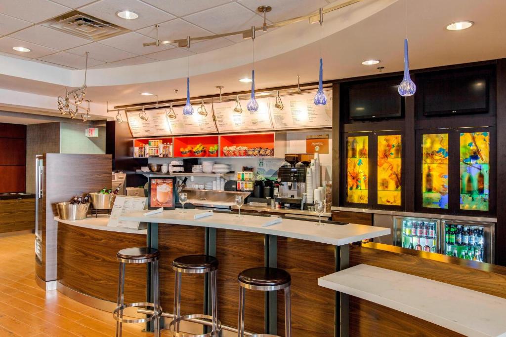 a bar in a restaurant with bar stools at Courtyard by Marriott Chicago Schaumburg/Woodfield Mall in Schaumburg