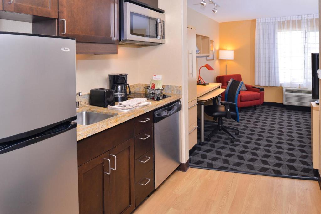 a kitchen with a refrigerator and a living room at TownePlace Suites by Marriott Las Vegas Henderson in Las Vegas