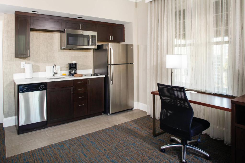 a kitchen with a refrigerator and a chair in a room at Residence Inn by Marriott Atlanta Midtown/Georgia Tech in Atlanta