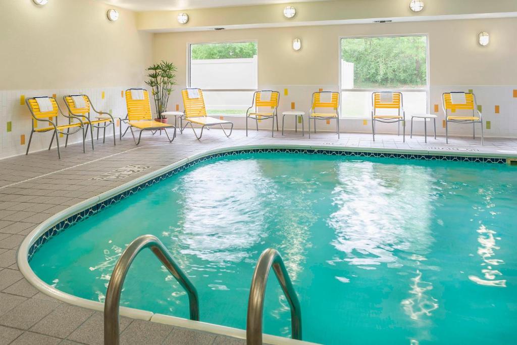 a pool in a hotel room with chairs and tables at Fairfield Inn & Suites Jackson in Jackson