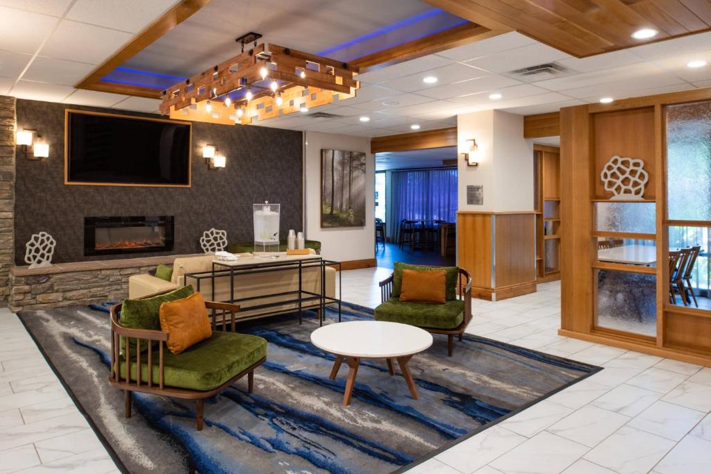 vestíbulo con sillas, mesa y TV en Fairfield Inn and Suites by Marriott Bakersfield Central, en Bakersfield