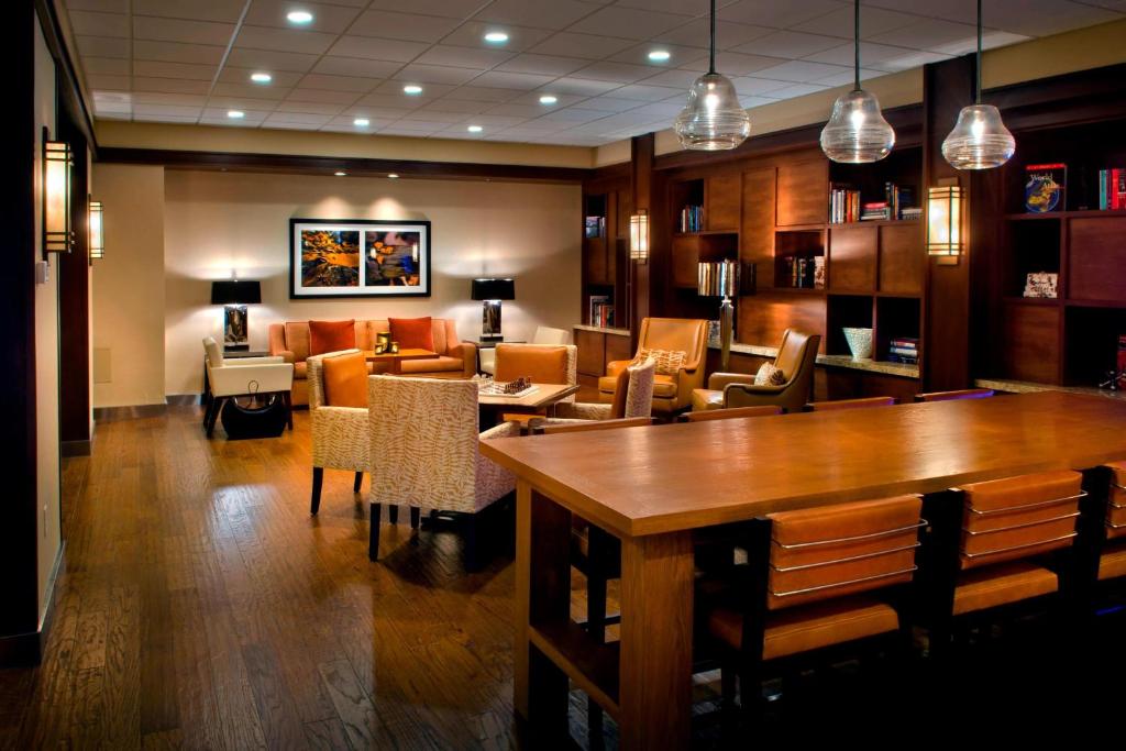 a restaurant with a table and chairs and a couch at Trumbull Marriott Shelton in Trumbull