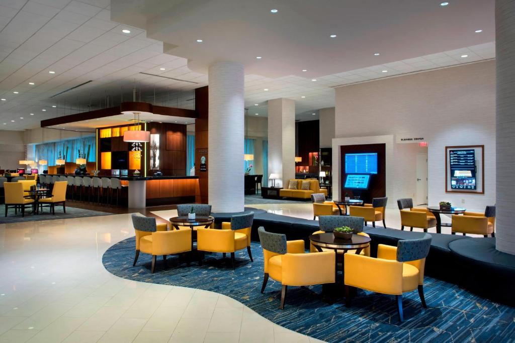 a lobby of a hotel with tables and chairs at BWI Airport Marriott in Linthicum Heights