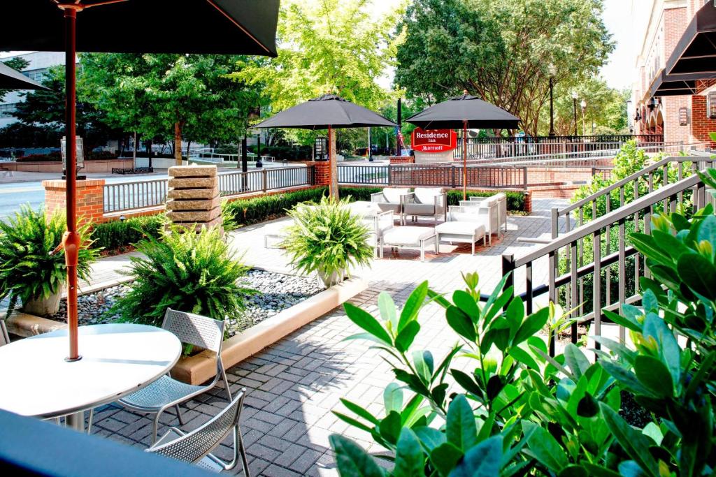 un patio al aire libre con mesas, sillas y sombrillas en Residence Inn Atlanta Midtown 17th Street en Atlanta