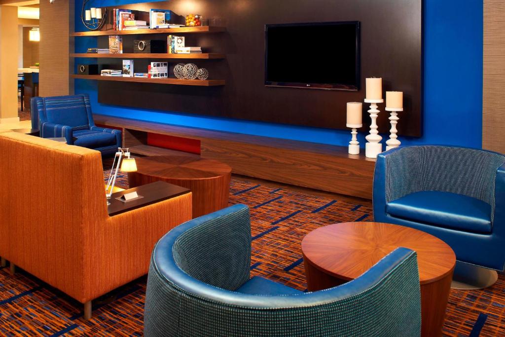 a lobby with a tv and chairs and a table at Courtyard by Marriott Cleveland Westlake in Westlake