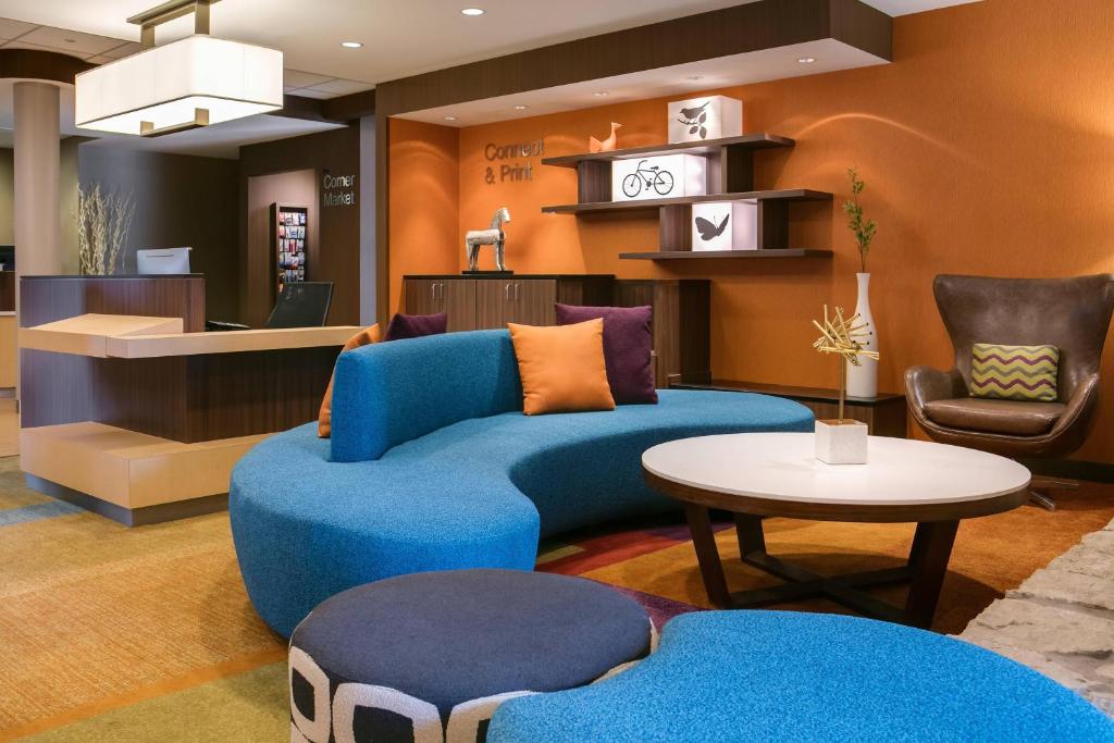 a living room with a blue couch and a table at Fairfield Inn Manhattan, Kansas in Manhattan