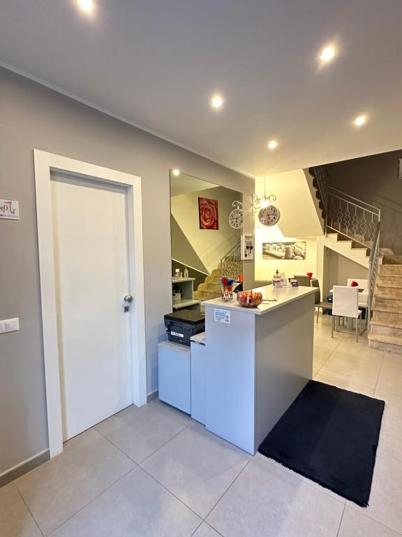 eine Küche mit einer weißen Tür und einer Treppe in der Unterkunft Le Tre Rose in Terrasini