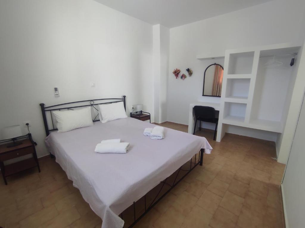 a bedroom with a large bed and a chair at Mama's House in Ios Chora