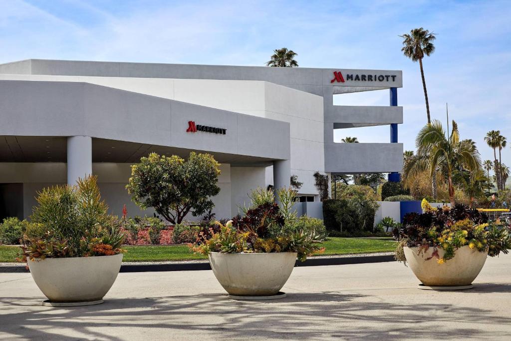 budynek z trzema dużymi doniczkami roślin przed nim w obiekcie Ventura Beach Marriott w mieście Ventura