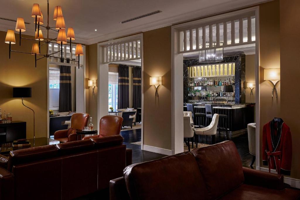A leather-seated salon with a cocktail bar visible through the adjoining room.
