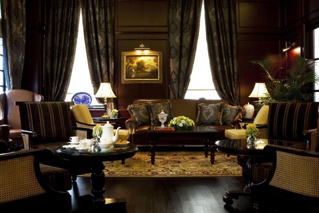 A richly furnished, low-lit lounge offers formal seating around a central coffee table.