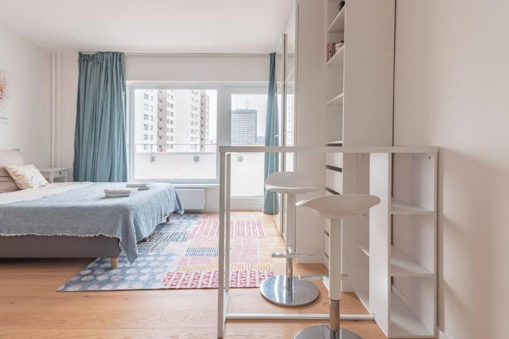 a white bedroom with a bed and a window at Modern Home in Central Berlin in Berlin