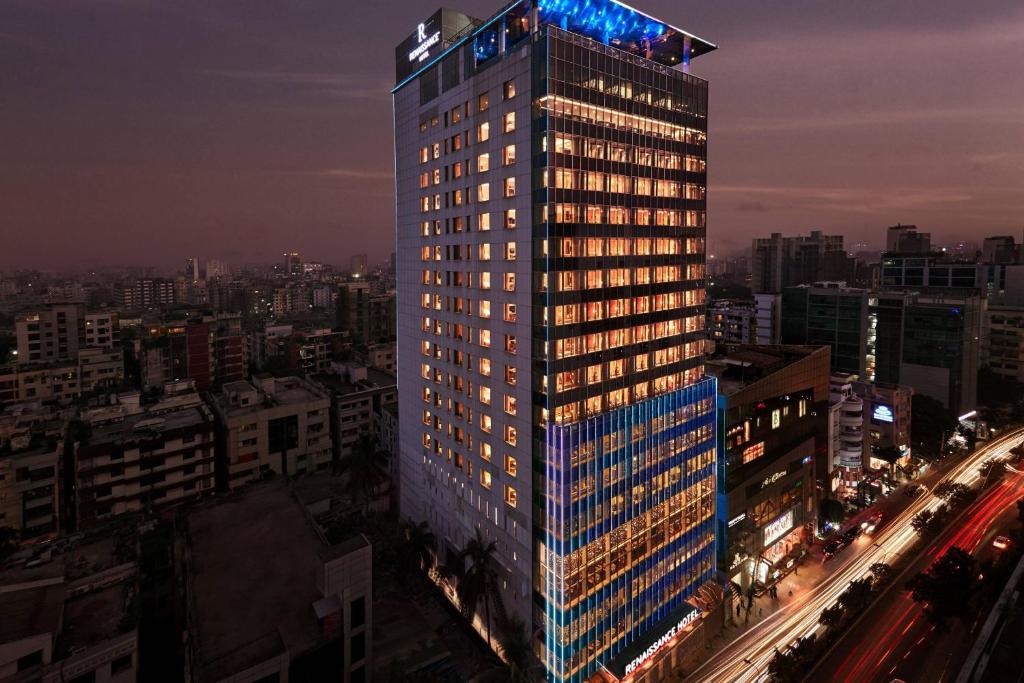 a tall building with lights on it in a city at Renaissance Dhaka Gulshan Hotel in Dhaka